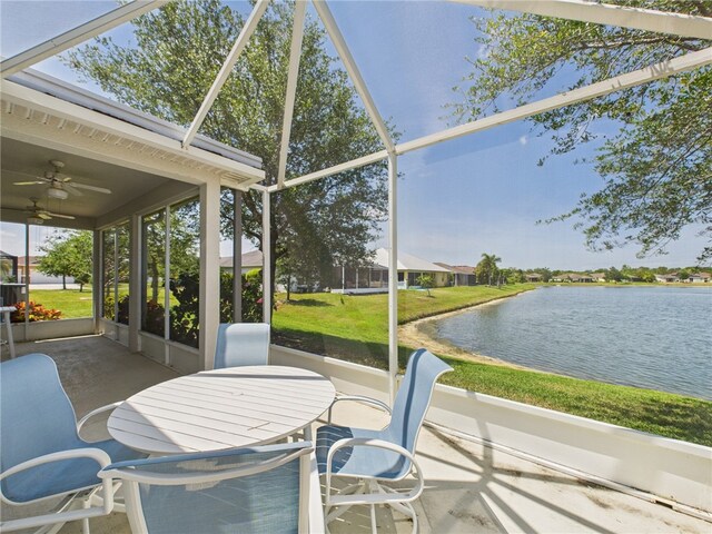 unfurnished sunroom featuring outdoor dining space, ceiling fan, and a water view
