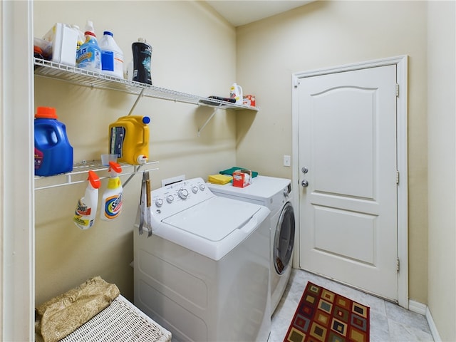 clothes washing area featuring laundry area, separate washer and dryer, and baseboards