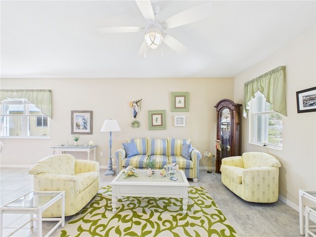 living room with plenty of natural light, a ceiling fan, and baseboards