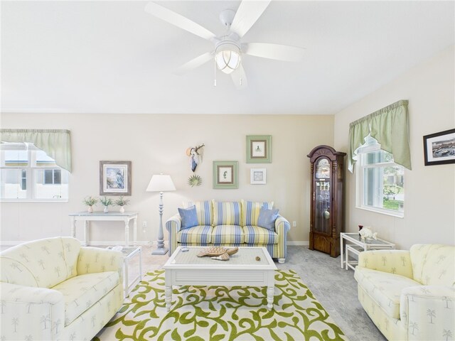 carpeted living area featuring ceiling fan and baseboards