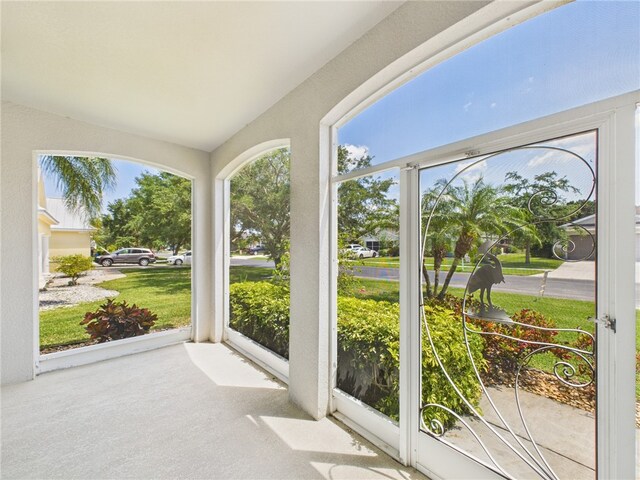 unfurnished sunroom with carpet flooring