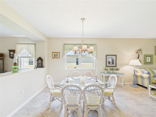 dining room with a chandelier and baseboards