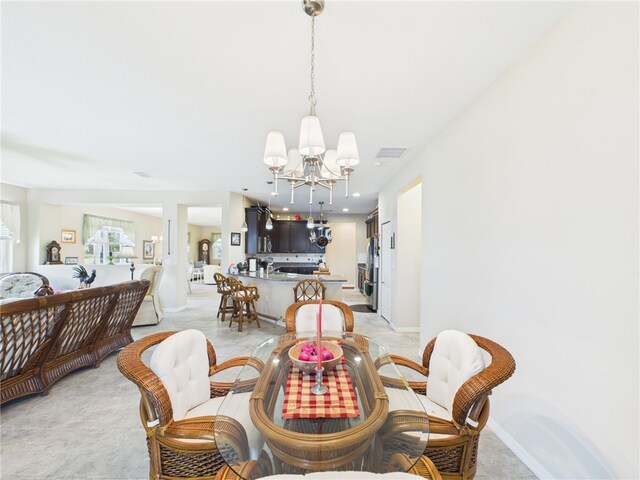 dining space with baseboards, visible vents, and an inviting chandelier