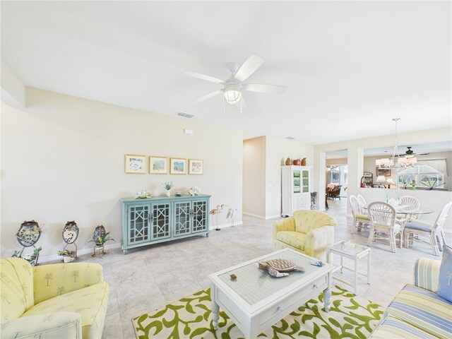 living room featuring baseboards, visible vents, and ceiling fan