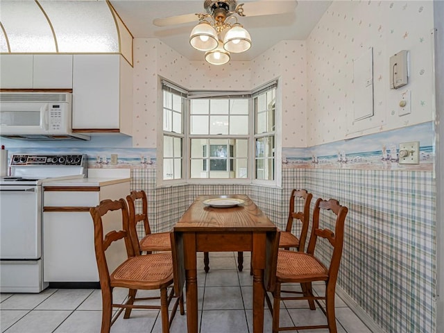 231 N Grove Isle Cir Unit 231, Vero Beach, FL 32962 - dining space with light tile patterned flooring, a ceiling fan, wainscoting, and wallpapered walls