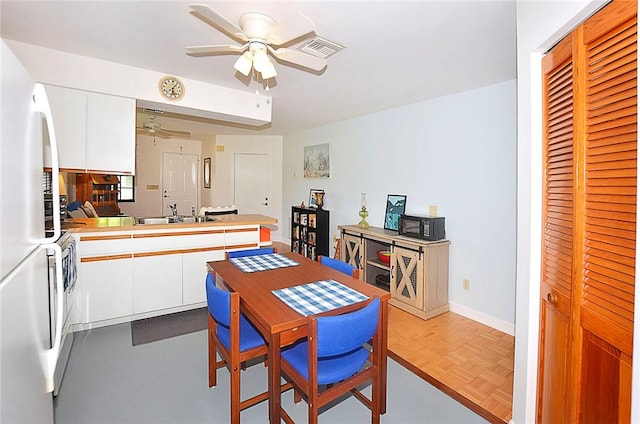 2440 88th Ave, Vero Beach, FL 32966 - kitchen with a ceiling fan, freestanding refrigerator, white cabinets, a peninsula, and light countertops