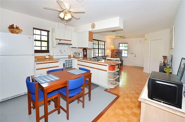 2440 88th Ave, Vero Beach, FL 32966 - kitchen with white appliances, a ceiling fan, extractor fan, a peninsula, and white cabinetry