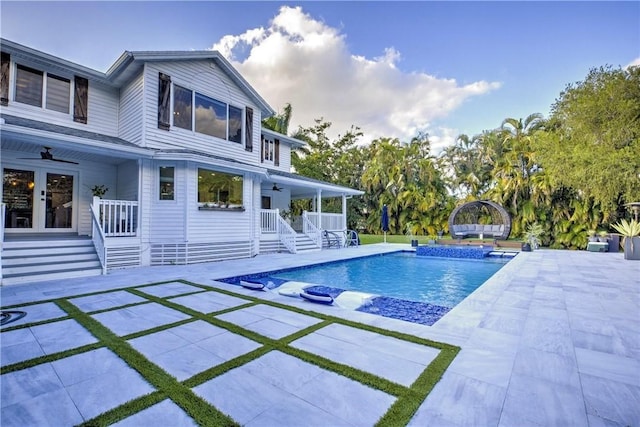 view of pool featuring pool water feature, ceiling fan, a patio area, and french doors