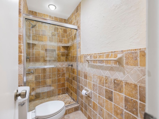 bathroom featuring tile walls, walk in shower, and toilet