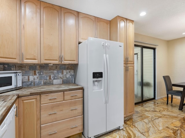 kitchen with butcher block countertops, tasteful backsplash, and white appliances