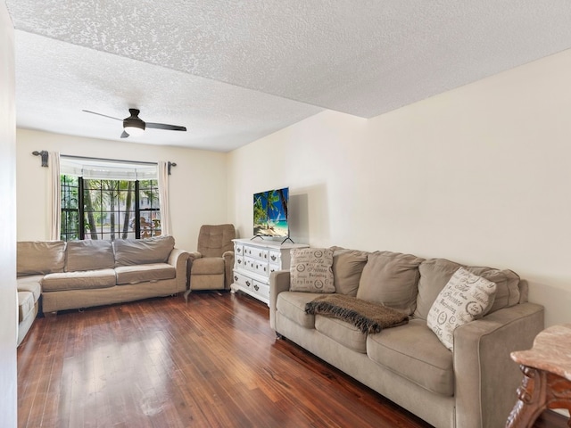 living room featuring dark hardwood / wood-style flooring, a textured ceiling, and ceiling fan