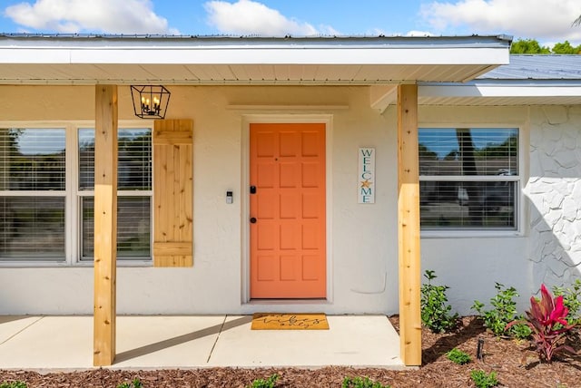 doorway to property featuring stucco siding