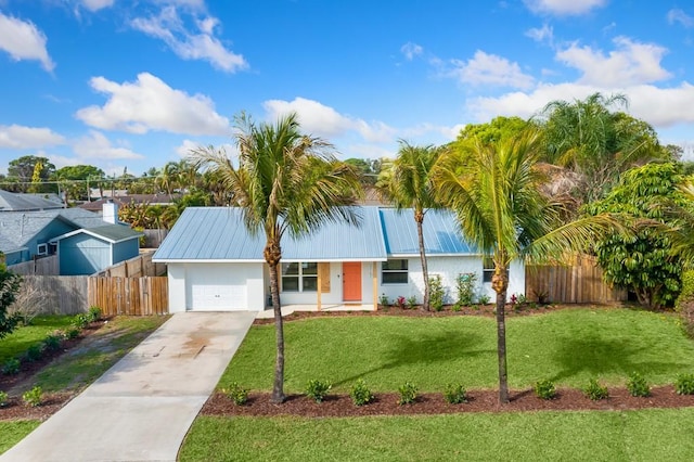 single story home featuring driveway, a garage, metal roof, fence, and a front yard