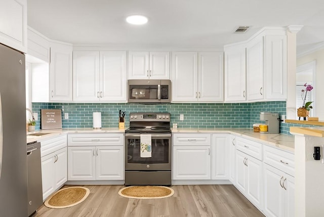 kitchen featuring light wood finished floors, visible vents, appliances with stainless steel finishes, and a sink