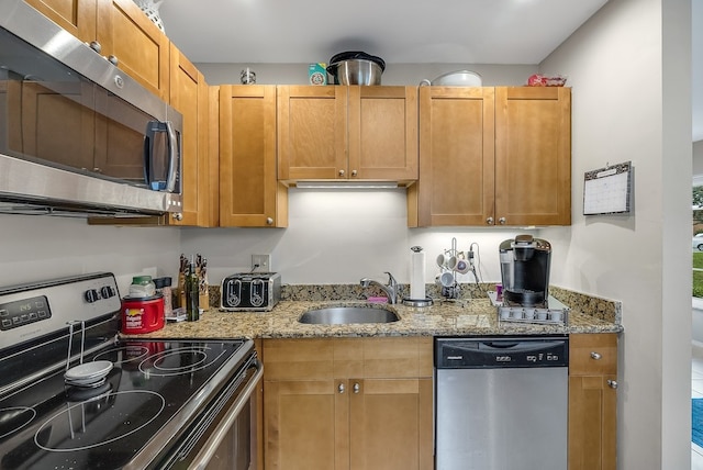 41 Woodland Dr Unit 102, Vero Beach, FL 32962 - kitchen with appliances with stainless steel finishes, a sink, and light stone countertops