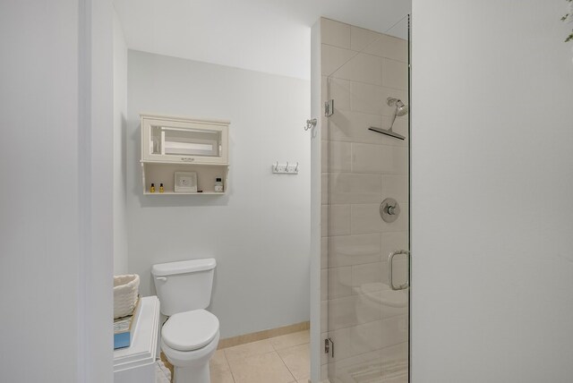 41 Woodland Dr Unit 102, Vero Beach, FL 32962 - bathroom with tile patterned floors, a stall shower, toilet, and baseboards