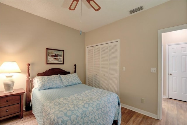 bedroom with a closet, light hardwood / wood-style flooring, and ceiling fan