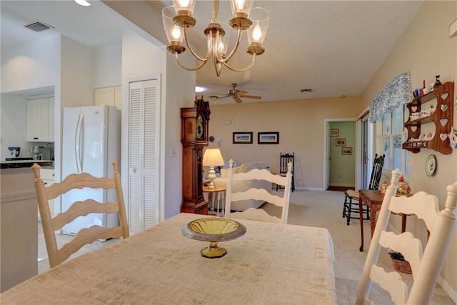 dining space with ceiling fan with notable chandelier and light carpet