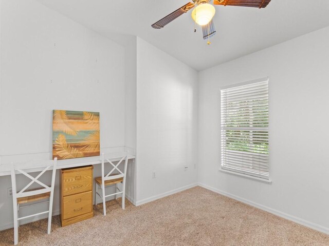 unfurnished office featuring light colored carpet and ceiling fan