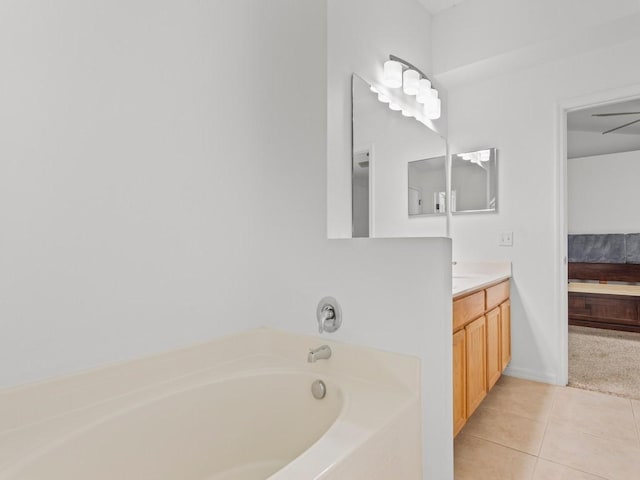 bathroom with a bathing tub, ceiling fan, tile patterned flooring, and vanity