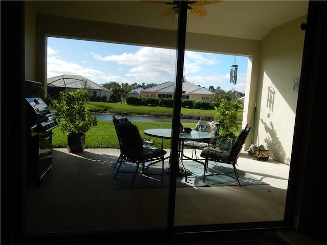 interior space with a water view and ceiling fan