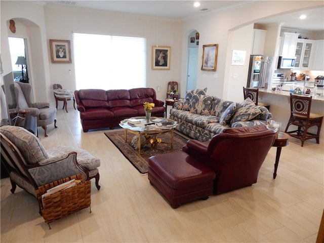 living room with ornamental molding and light tile patterned floors