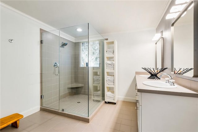 bathroom featuring tile patterned floors, ornamental molding, a shower with shower door, and vanity