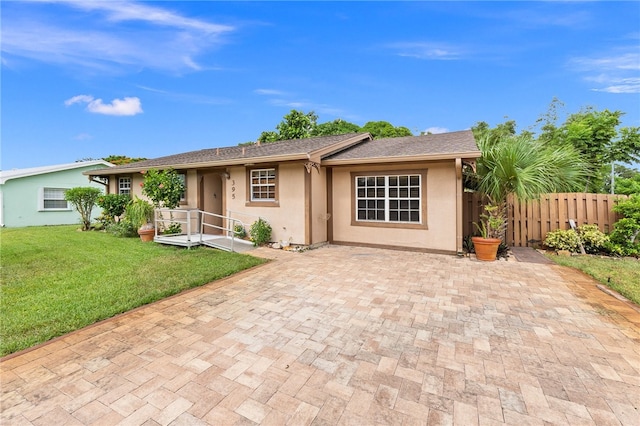 ranch-style house with a front lawn and a patio