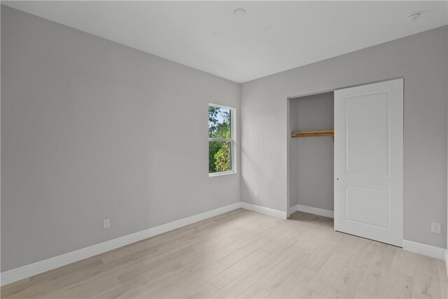 unfurnished bedroom with a closet and light wood-type flooring