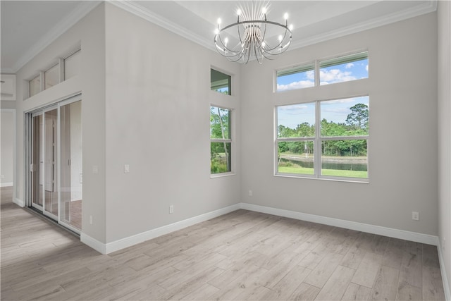 empty room featuring ornamental molding, a chandelier, and light hardwood / wood-style floors