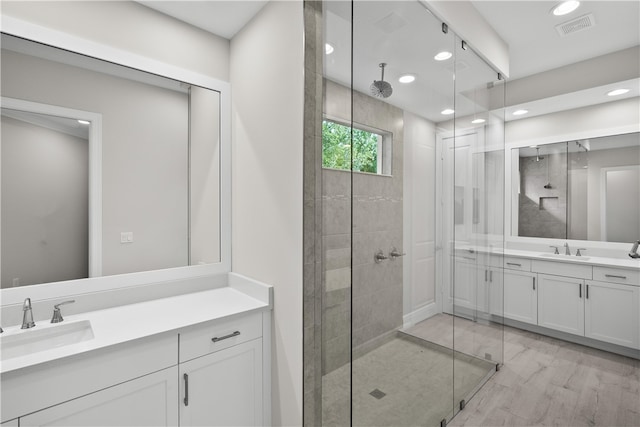 bathroom with hardwood / wood-style flooring, a shower with door, and vanity