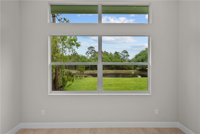 spare room with light wood-type flooring and a water view