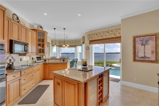 kitchen with hanging light fixtures, crown molding, a water view, and a kitchen island