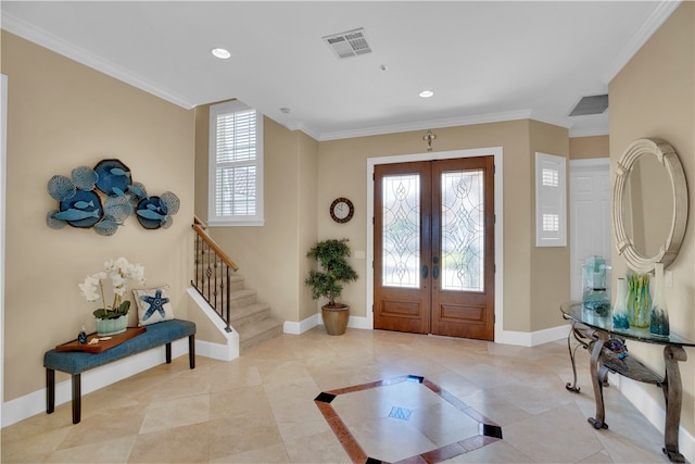 entrance foyer featuring ornamental molding, french doors, a healthy amount of sunlight, and light tile patterned floors