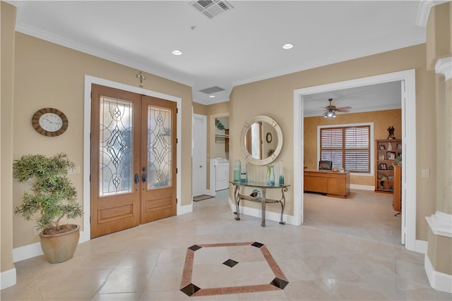 tiled entryway with french doors, ceiling fan, crown molding, and washer and dryer