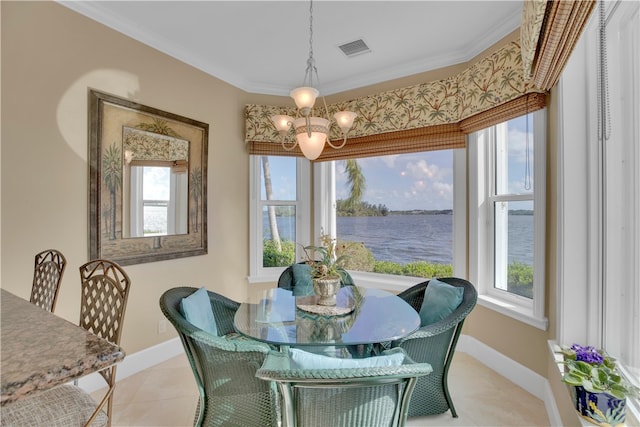 dining area featuring a water view, a chandelier, crown molding, and light tile patterned flooring