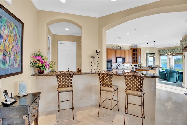 kitchen featuring black appliances, crown molding, dark stone counters, hanging light fixtures, and kitchen peninsula