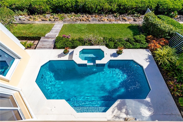 view of pool featuring a lawn and an in ground hot tub