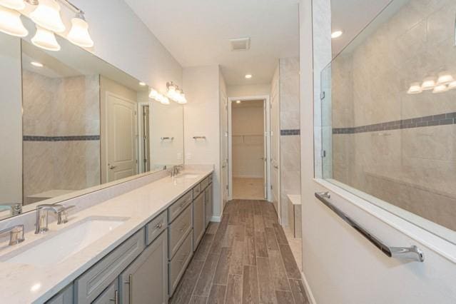 bathroom with vanity and a tile shower