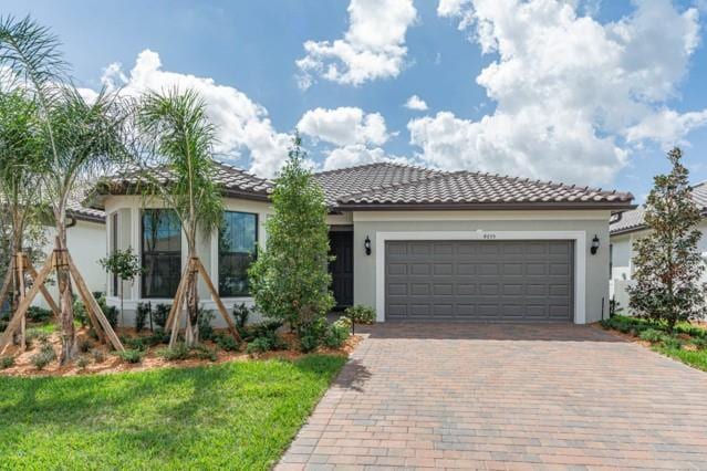 mediterranean / spanish house featuring a garage and a front yard