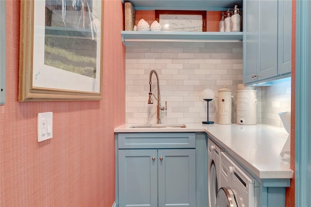 kitchen with washer / dryer, sink, and backsplash