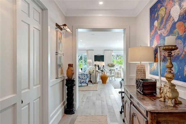 hallway with crown molding and light hardwood / wood-style floors