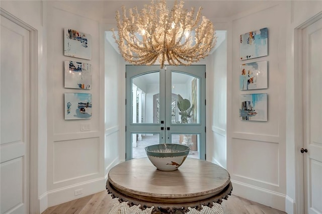 interior space with french doors and a chandelier