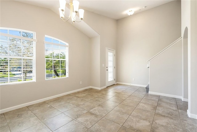 entrance foyer featuring a chandelier, high vaulted ceiling, arched walkways, tile patterned flooring, and baseboards