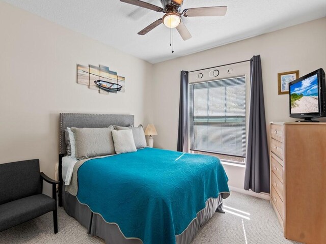 bedroom featuring light carpet and a ceiling fan