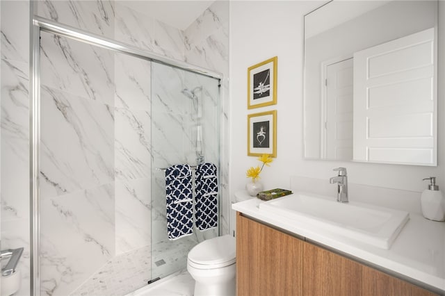 bathroom featuring vanity, toilet, and a shower with shower door