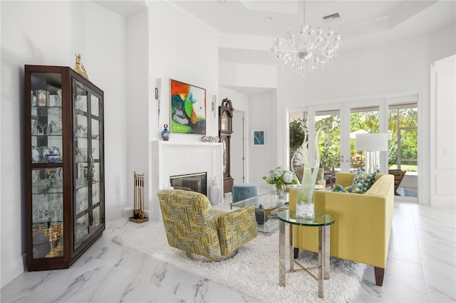 living room with a high ceiling, an inviting chandelier, french doors, crown molding, and a tray ceiling