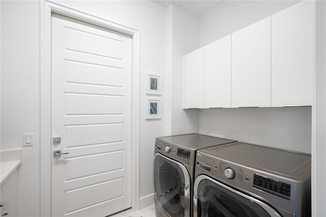 laundry room featuring washer and dryer and cabinets