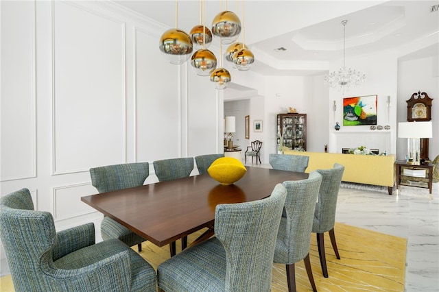 dining room featuring a raised ceiling, crown molding, and a notable chandelier