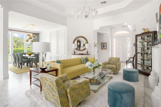 living room with a chandelier, a raised ceiling, and crown molding